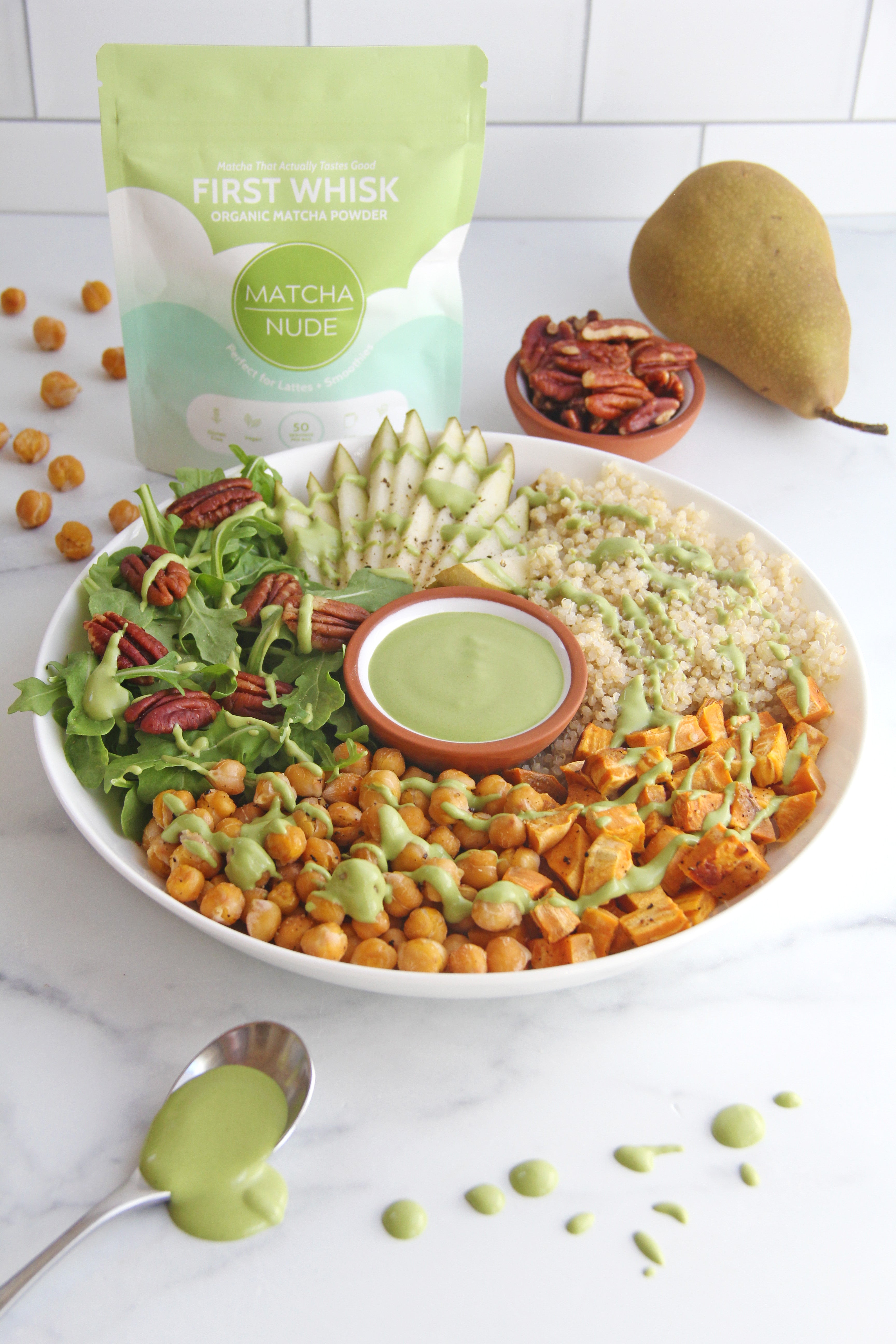 Autumn Matcha Quinoa Power Bowl featuring roasted chickpeas, sweet potatoes, arugula, sliced pear, quinoa, and matcha tahini sauce made with Matcha Nude First Whisk organic matcha powder.