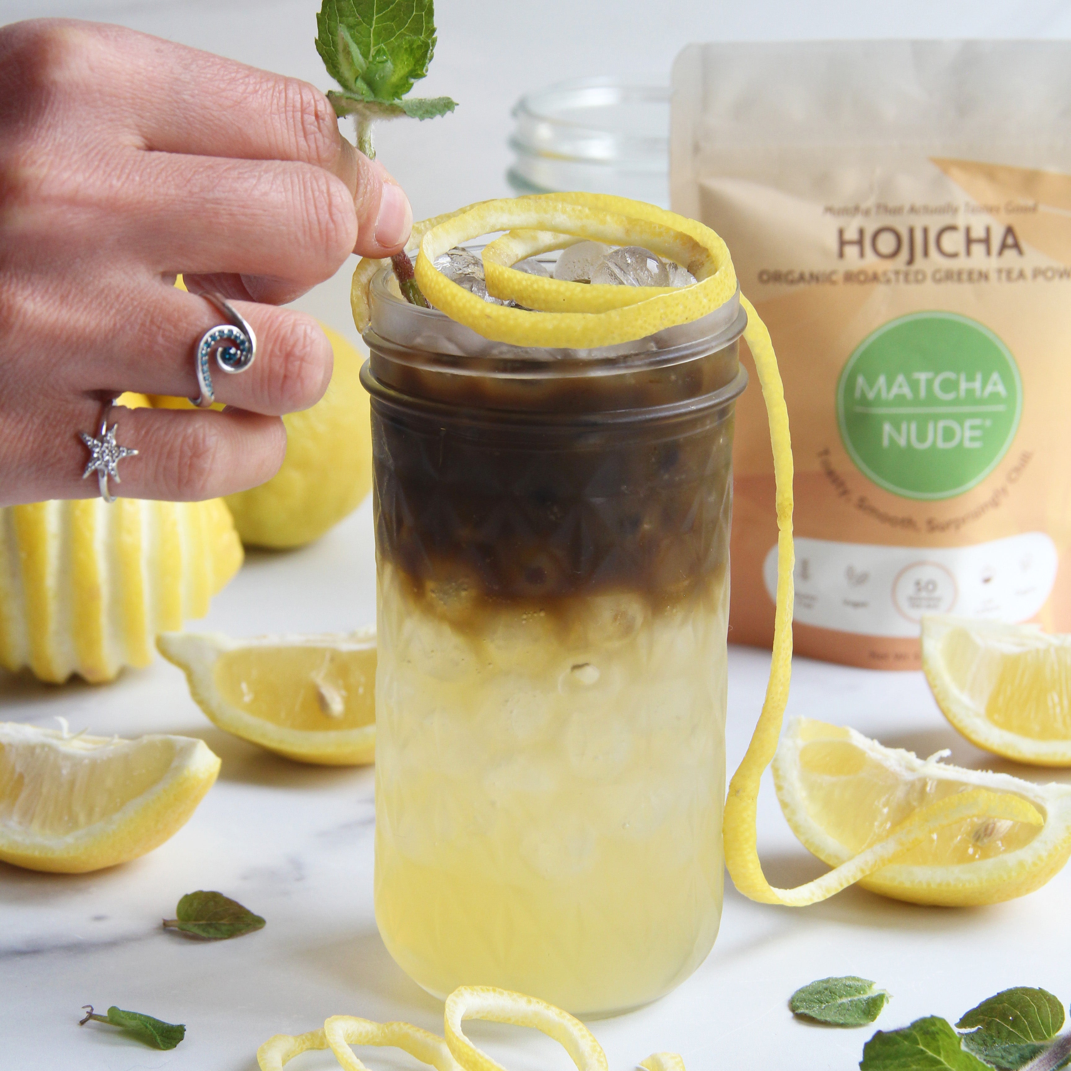 Hojicha Arnold Palmer made with Matcha Nude Hojicha Powder, fresh lemonade, ice, lemon peel, and mint garnish.