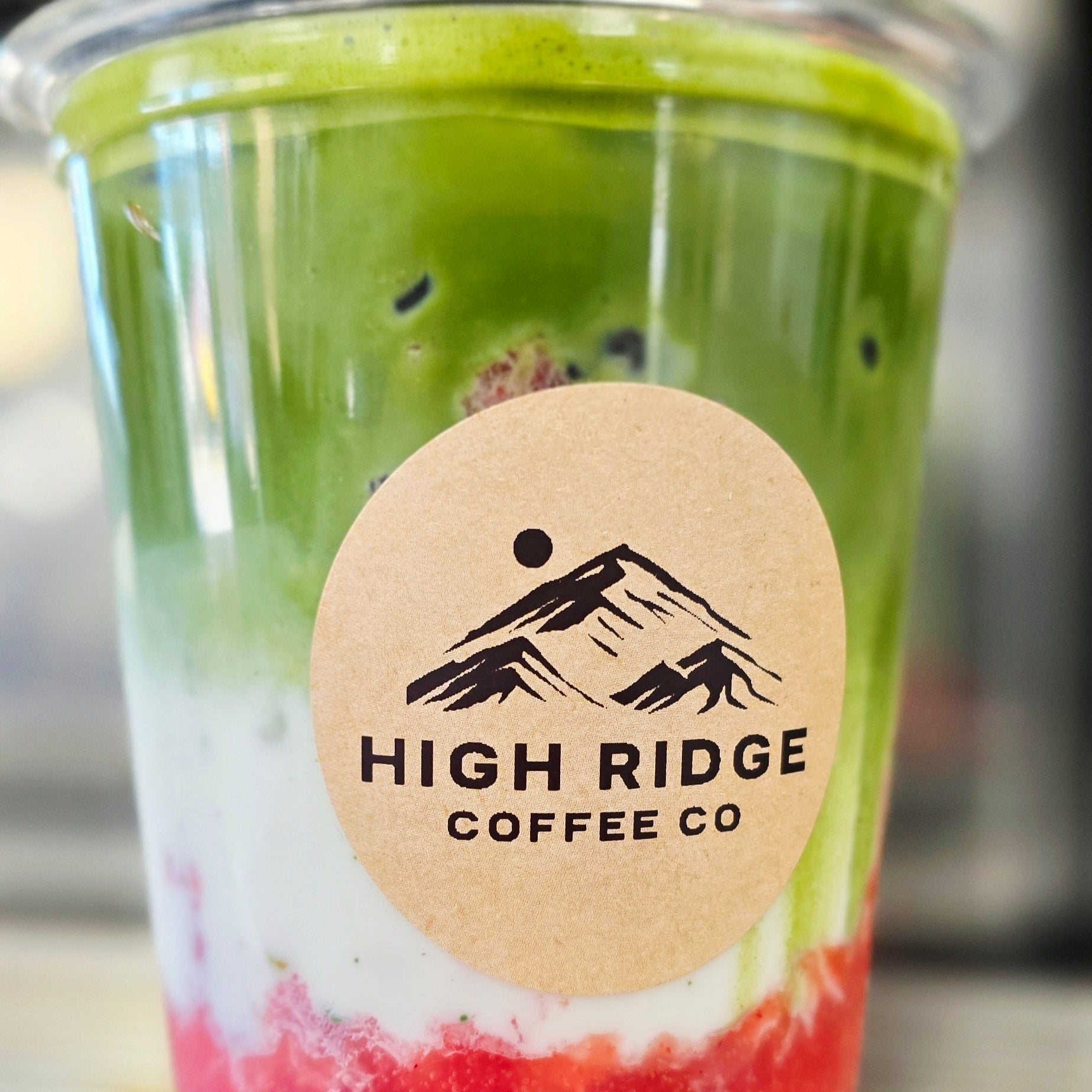 Berry Bliss Matcha from High Ridge Coffee Co featuring fresh strawberries, milk, and Matcha Nude ceremonial matcha layered over ice.