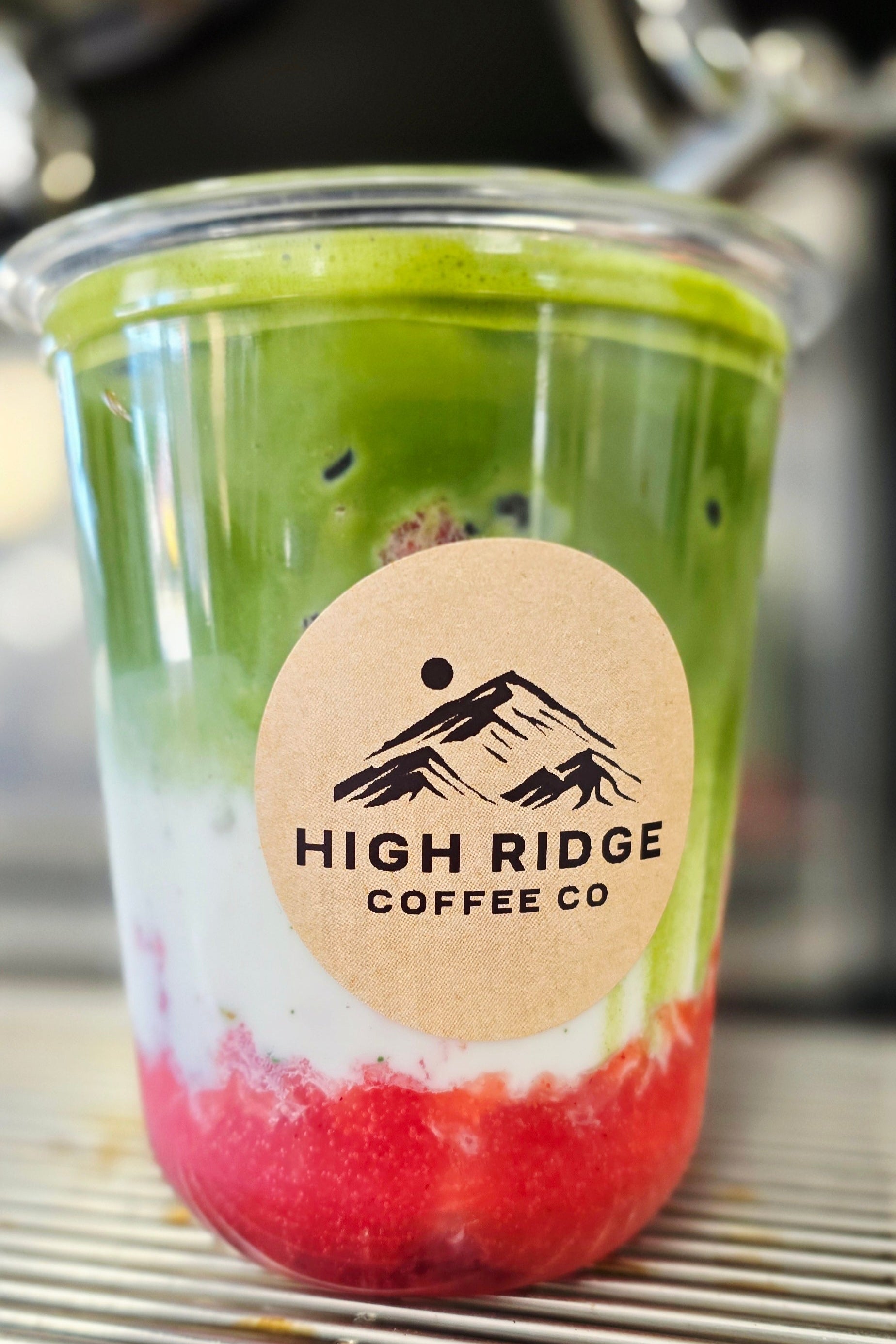 Berry Bliss Matcha from High Ridge Coffee Co featuring fresh strawberries, milk, and Matcha Nude ceremonial matcha layered over ice.