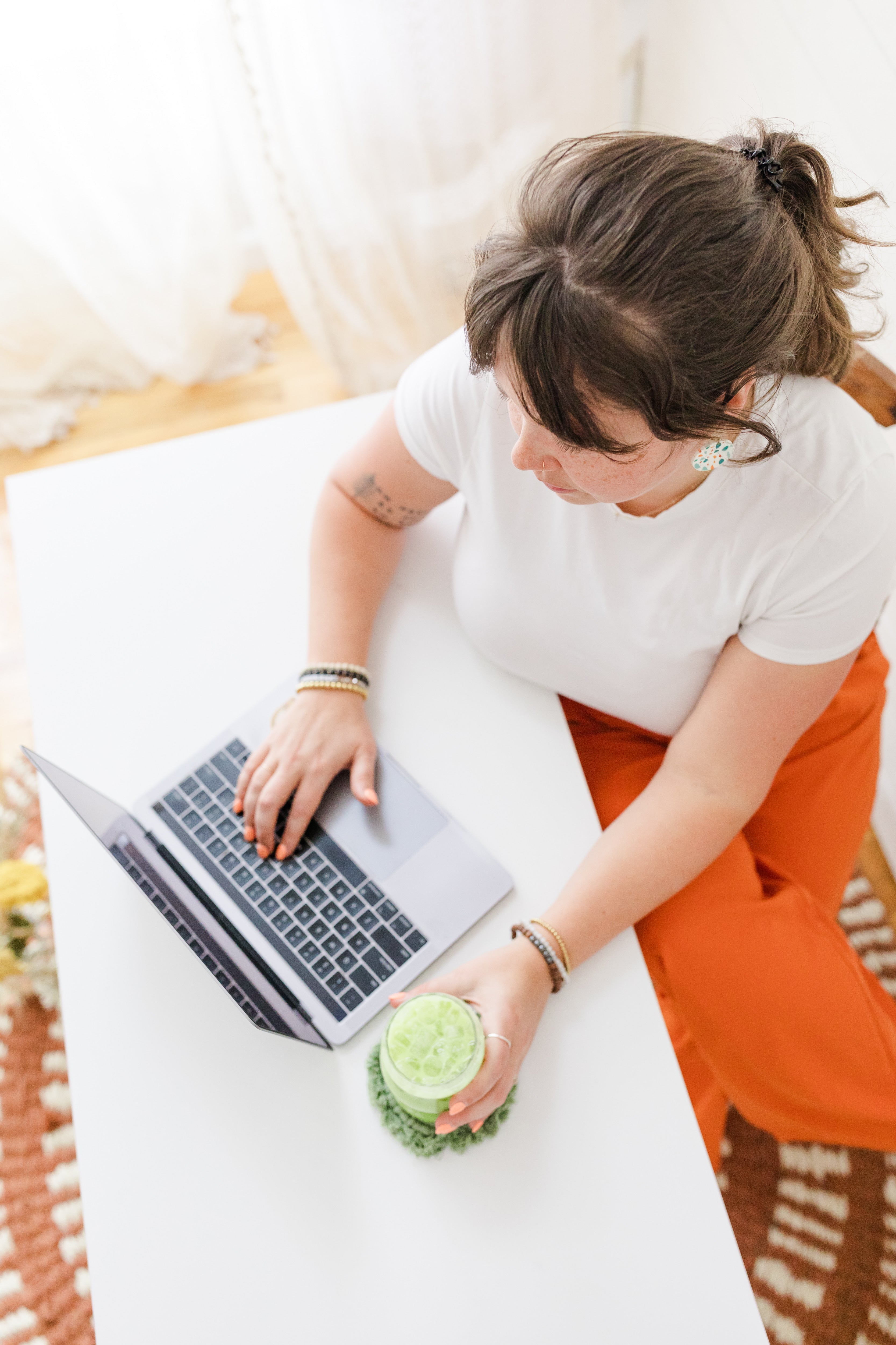 Woman working on laptop with matcha while reviewing matcha heavy metals testing and safety