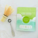 Beginner matcha starter kit with First Whisk matcha, bamboo whisk, and matcha spoon on marble surface