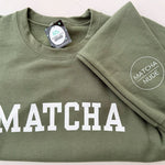 Unisex green MATCHA crewneck sweatshirt with Matcha Nude sleeve logo – printed by Moonlight Makers in Asheville, NC