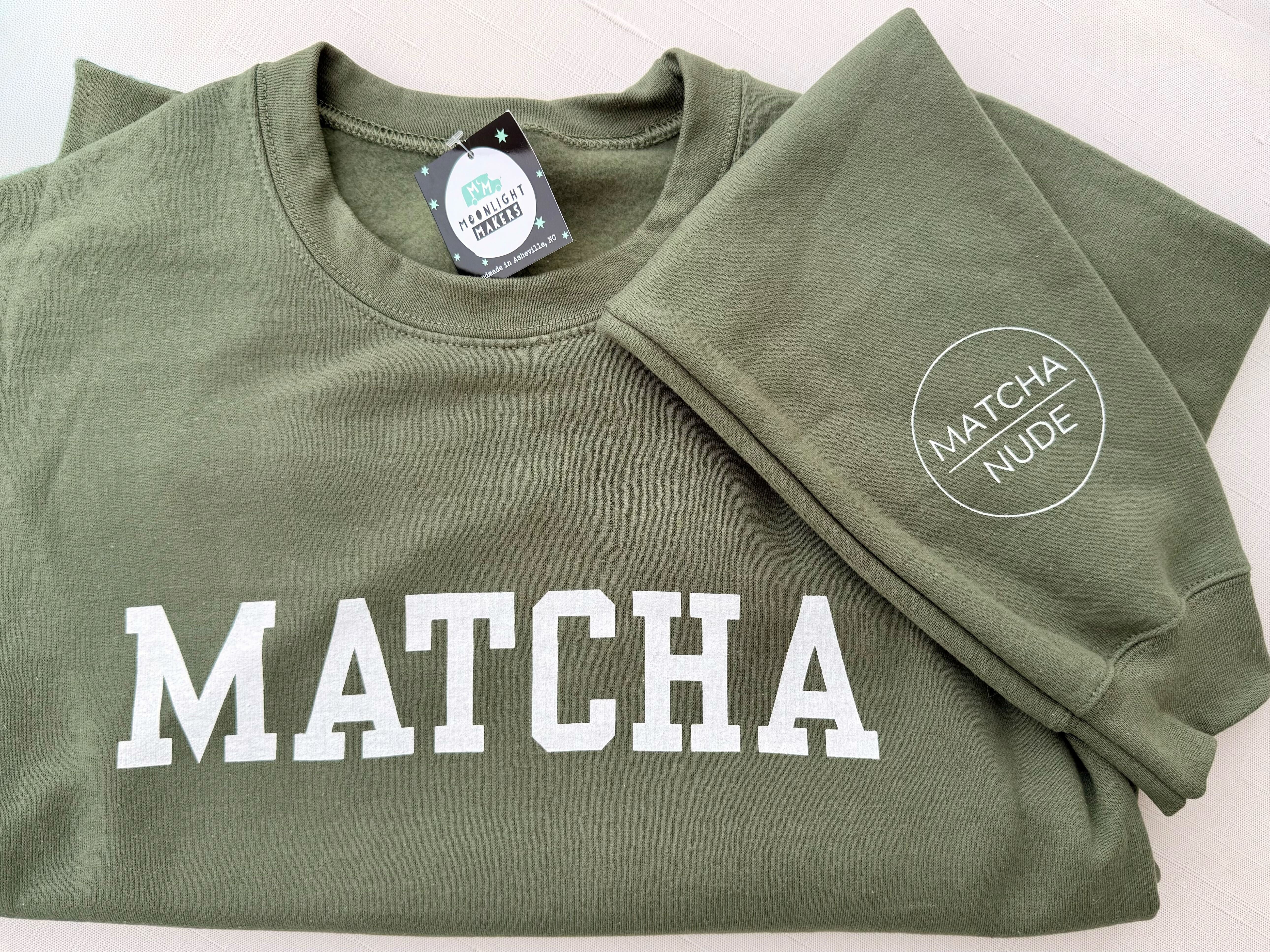 Unisex green MATCHA crewneck sweatshirt with Matcha Nude sleeve logo – printed by Moonlight Makers in Asheville, NC