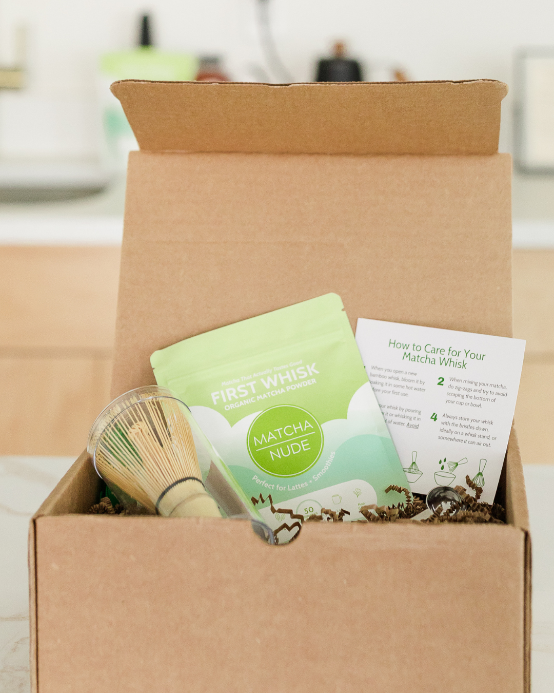 Matcha Nude starter pack with matcha powder, bamboo whisk, and spoon in open box