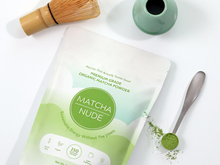 Load image into Gallery viewer, Premium organic matcha powder by Matcha Nude showcased with a traditional bamboo whisk and a green ceramic whisk holder. This sustainable matcha brand offers clean energy without jitters, featuring gluten-free, vegan, and non-GMO benefits. Perfect for matcha enthusiasts seeking quality and eco-friendly choices.