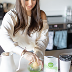 Woman whisking Matcha Nude Premium Matcha in glass bowl at home